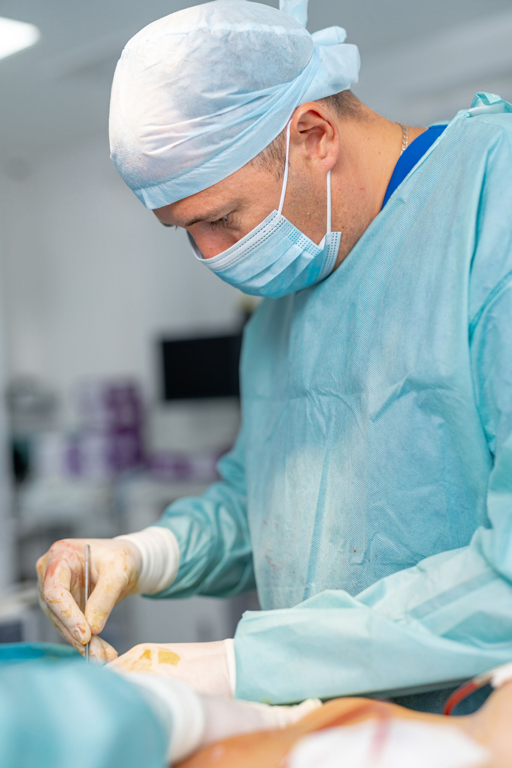 Surgeon performing precise surgical operation. Doctor in medical gown carefully operates in modern clinical operating room during plastic surgery procedure.